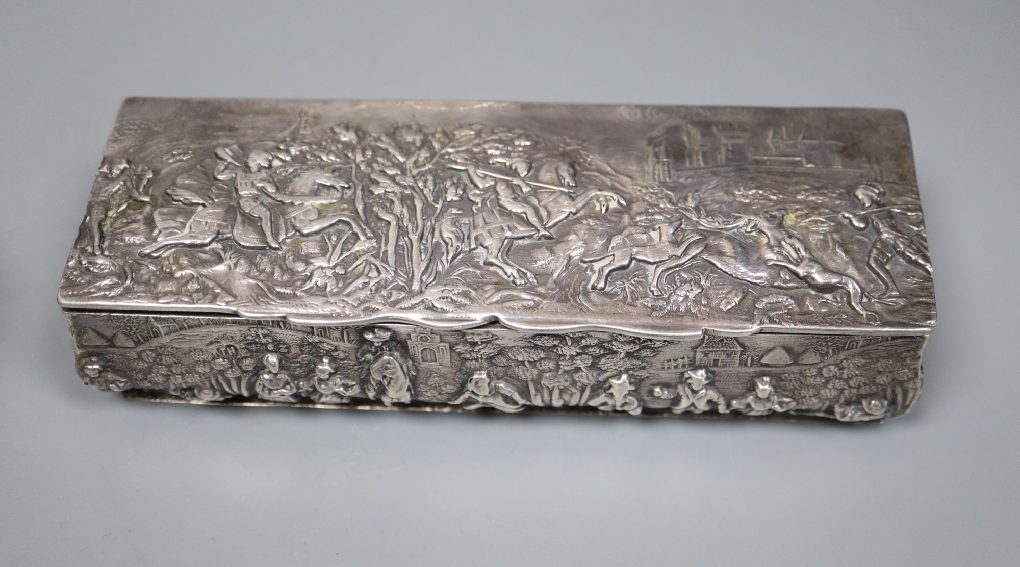 A Victorian silver rectangular box embossed with medieval hunting scenes, 15.3cm and two other embossed silver trinket boxes,